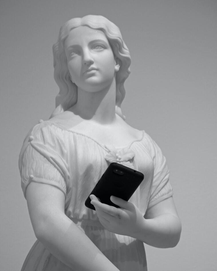 Statua di marmo bianco con telefono cellulare